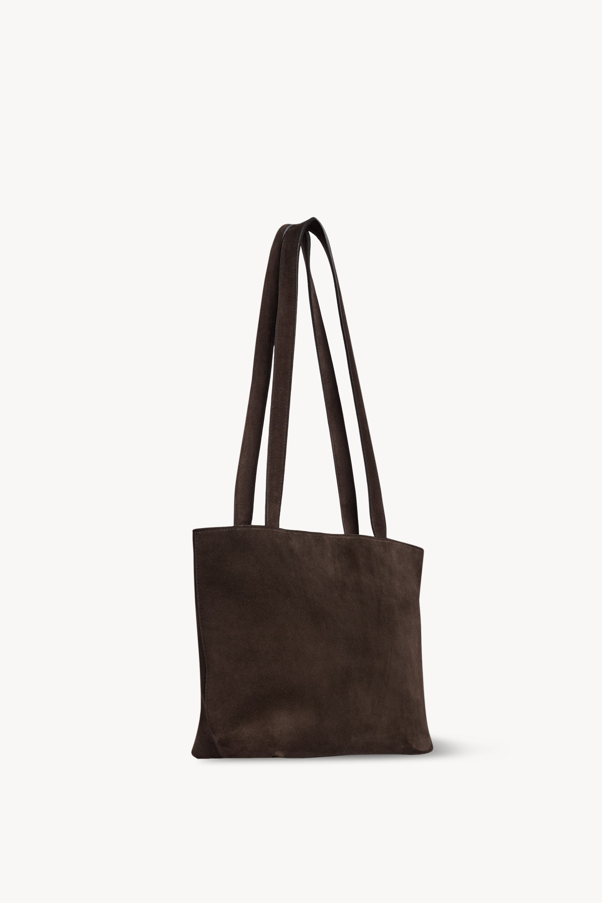 Dark brown The Row Parker Bag viewed from a rear angle with flat shoulder straps